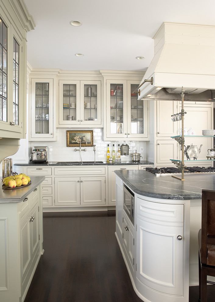 Design ideas for a large transitional l-shaped kitchen in New York with an undermount sink, recessed-panel cabinets, white cabinets, marble benchtops, white splashback, ceramic splashback, dark hardwood floors and with island.
