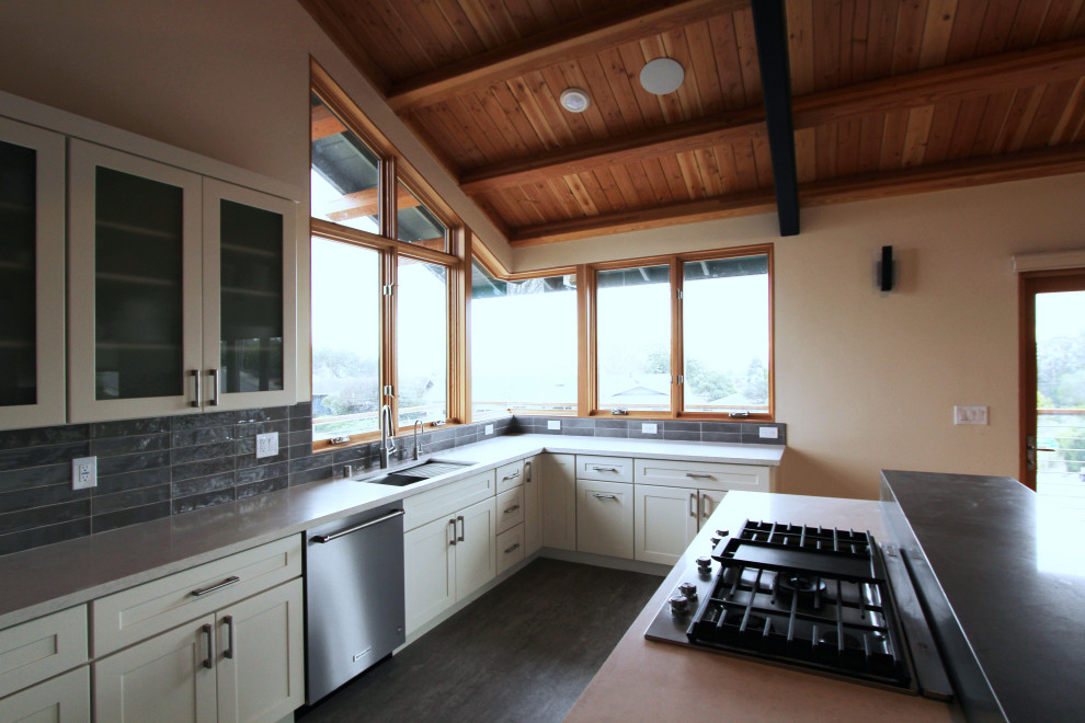 Open concept kitchen - mid-sized transitional l-shaped gray floor open concept kitchen idea with an undermount sink, shaker cabinets, white cabinets, quartz countertops, gray backsplash, ceramic backsplash, stainless steel appliances, an island and multicolored countertops