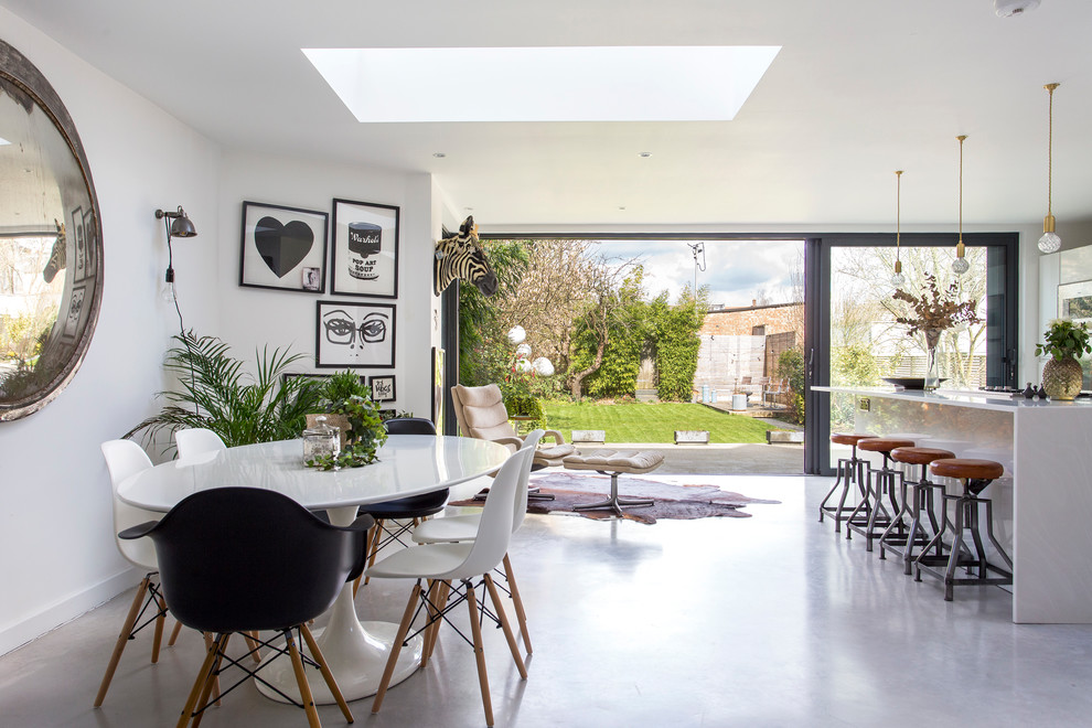 Design ideas for a mid-sized contemporary kitchen/dining combo in London with white walls, concrete floors and grey floor.