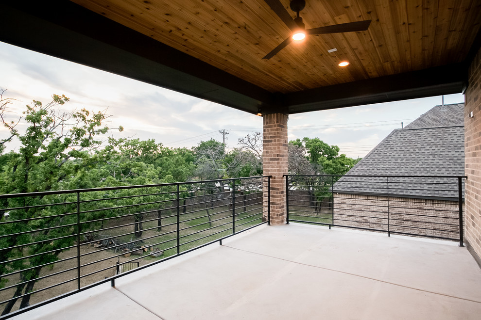 Design ideas for a mid-sized modern balcony in Dallas with a roof extension and metal railing.