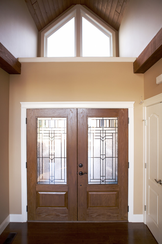 Design ideas for a traditional front door in Vancouver with beige walls, medium hardwood floors, a double front door and a medium wood front door.