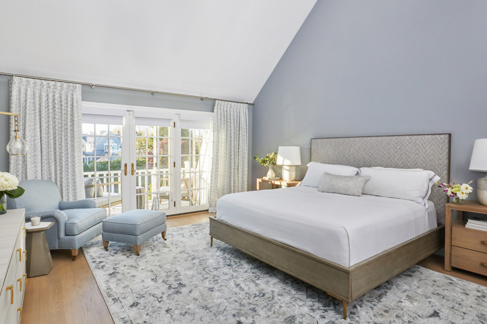 Diseño de dormitorio principal costero de tamaño medio sin chimenea con paredes azules y suelo de madera en tonos medios