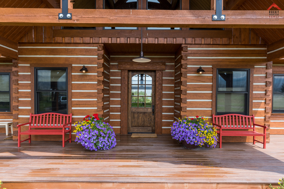 Example of a mid-sized mountain style medium tone wood floor and brown floor foyer design with white walls and a dark wood front door