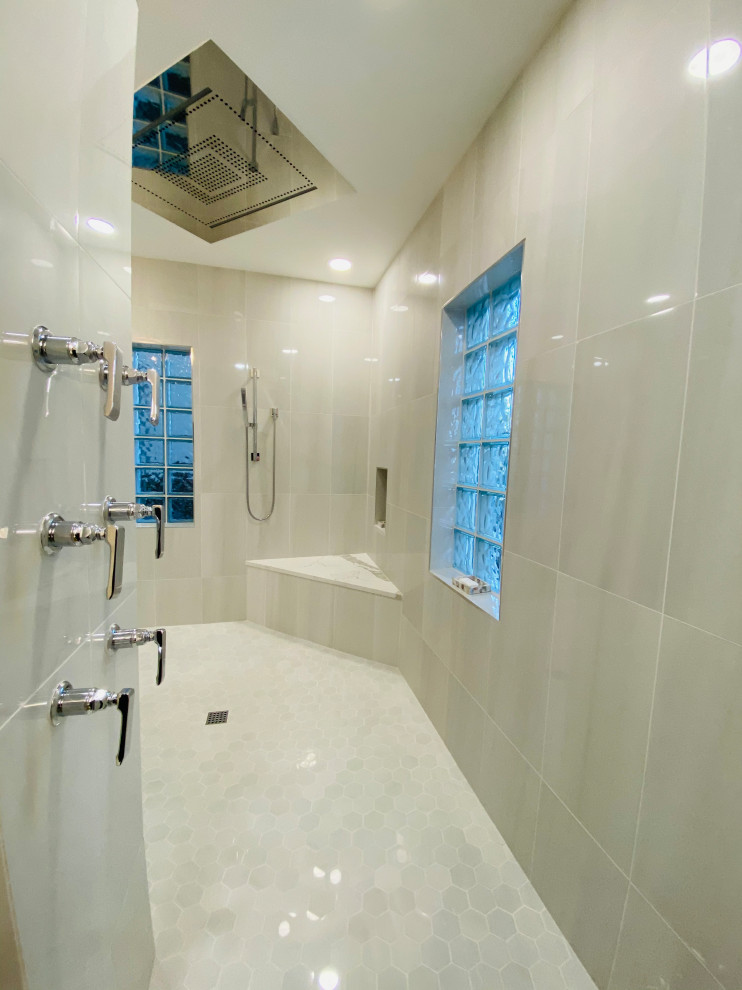 Photo of a large modern master bathroom in Tampa with recessed-panel cabinets, beige cabinets, a freestanding tub, a double shower, a bidet, gray tile, marble, grey walls, marble floors, an undermount sink, marble benchtops, an open shower, white benchtops, a niche, a double vanity and a built-in vanity.
