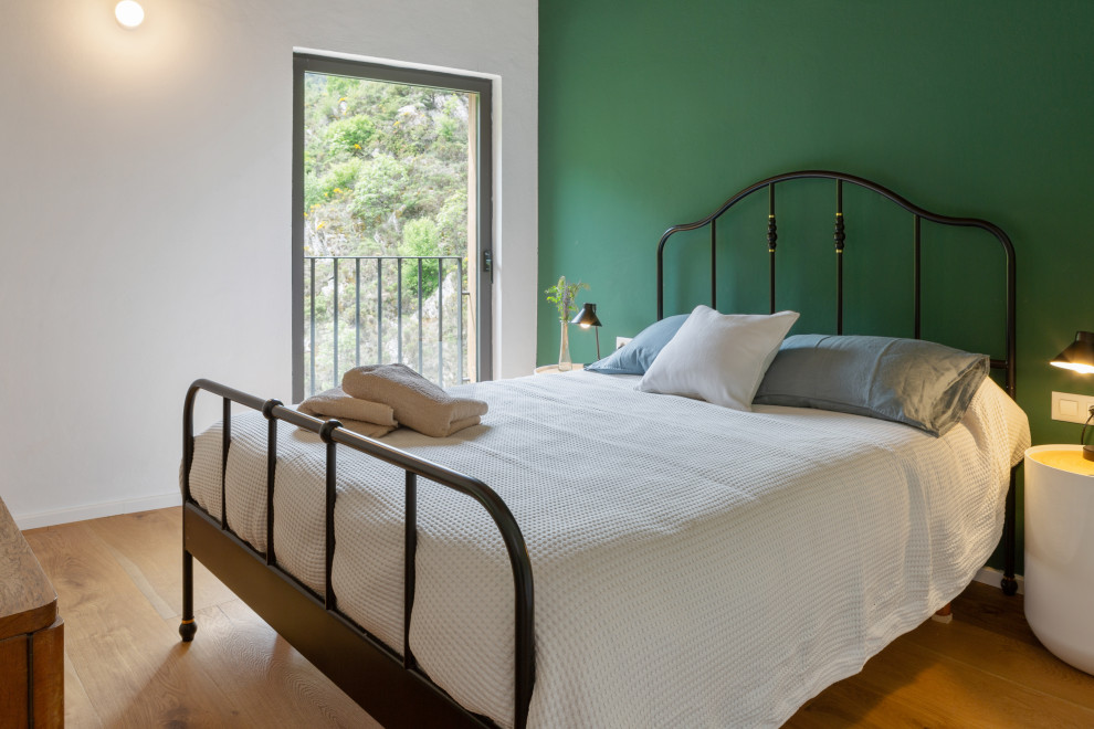 Diseño de habitación de invitados blanca y madera minimalista de tamaño medio con paredes verdes, suelo de madera en tonos medios, suelo marrón, vigas vistas y con escritorio