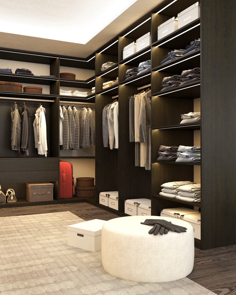 This is an example of a large modern dressing room in New York with open cabinets and dark wood cabinets.