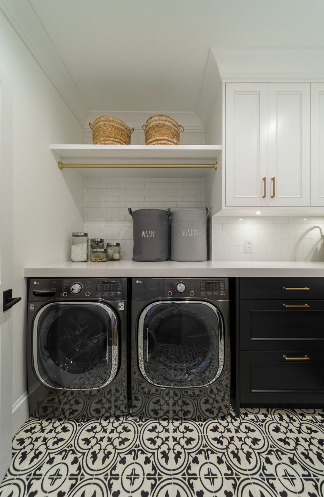 Design ideas for a transitional laundry room in Vancouver with shaker cabinets, black cabinets, white walls, a side-by-side washer and dryer, multi-coloured floor and white benchtop.