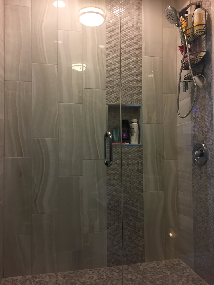Photo of a mid-sized bathroom in Chicago with an alcove shower, gray tile, mosaic tile, grey walls, grey floor and a hinged shower door.