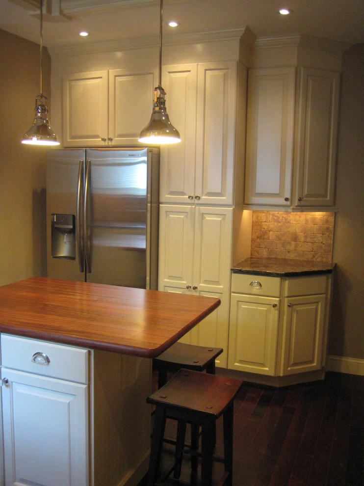 Example of a transitional l-shaped eat-in kitchen design in Philadelphia with a single-bowl sink, raised-panel cabinets, white cabinets, granite countertops, brown backsplash, stone tile backsplash and stainless steel appliances
