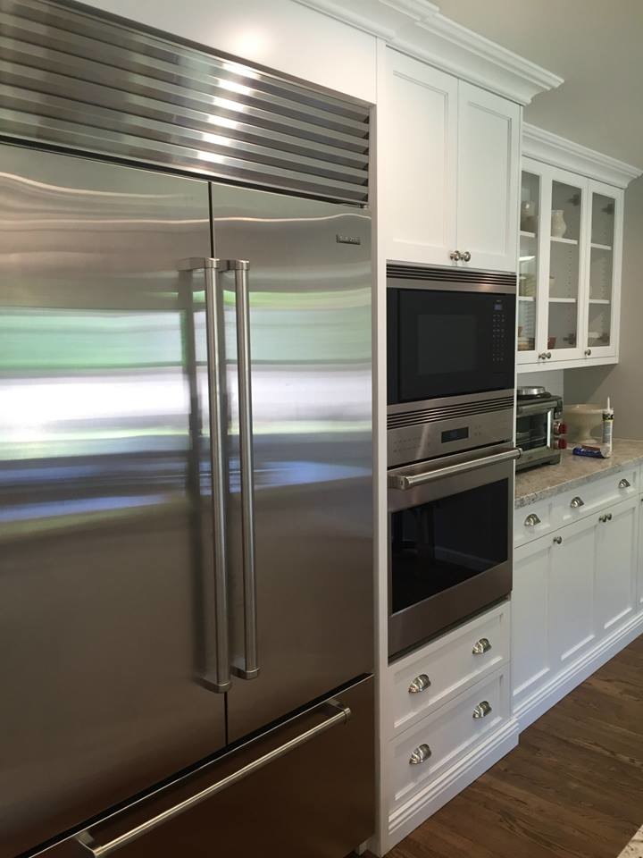 Inspiration for a large transitional medium tone wood floor kitchen remodel in Phoenix with an undermount sink, shaker cabinets, white cabinets, granite countertops, white backsplash, subway tile backsplash, stainless steel appliances and an island
