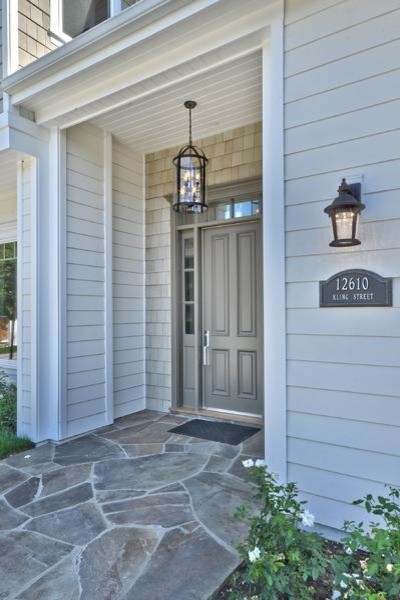 Photo of a mid-sized transitional front door in Other with grey walls, slate floors, a single front door and a gray front door.