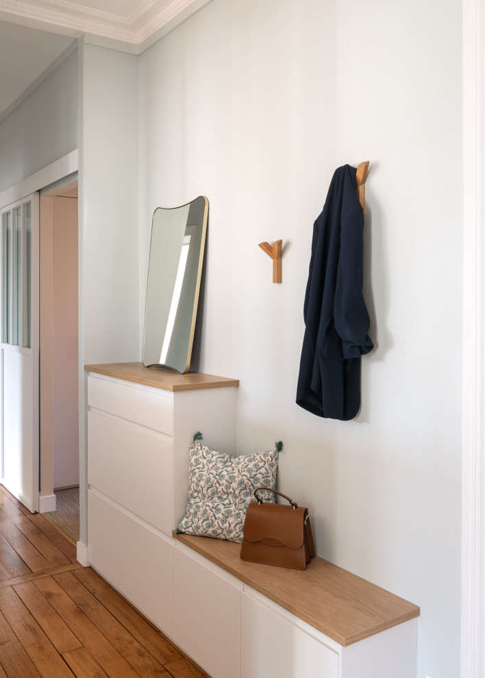 На фото: большая узкая прихожая в современном стиле с синими стенами, светлым паркетным полом, поворотной входной дверью, белой входной дверью и коричневым полом с