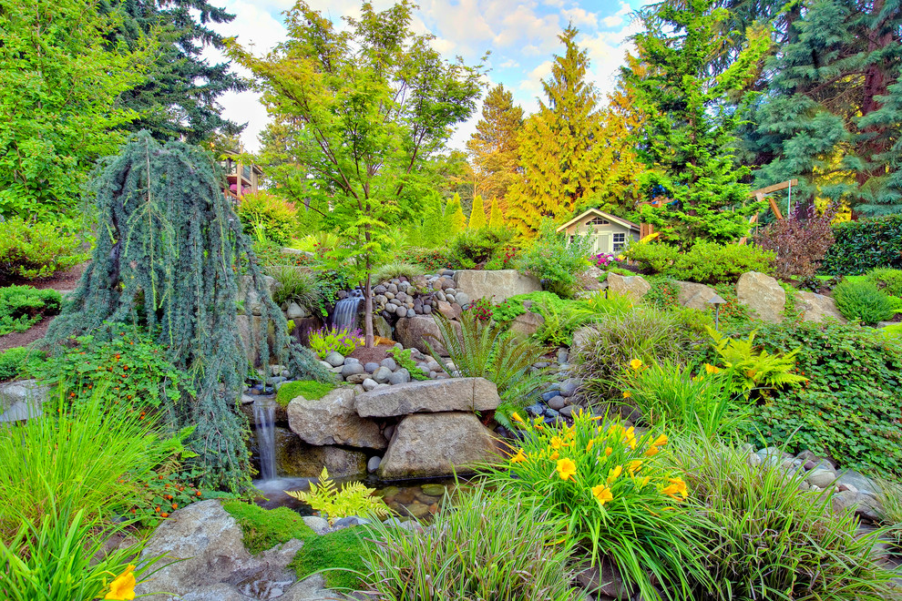 Inspiration for a large traditional backyard patio in Seattle with a water feature, natural stone pavers and no cover.
