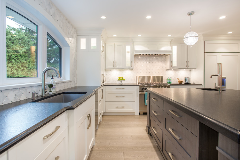 Eat-in kitchen - large transitional l-shaped medium tone wood floor and beige floor eat-in kitchen idea in Vancouver with an undermount sink, shaker cabinets, white cabinets, granite countertops, gray backsplash, marble backsplash, stainless steel appliances, an island and black countertops