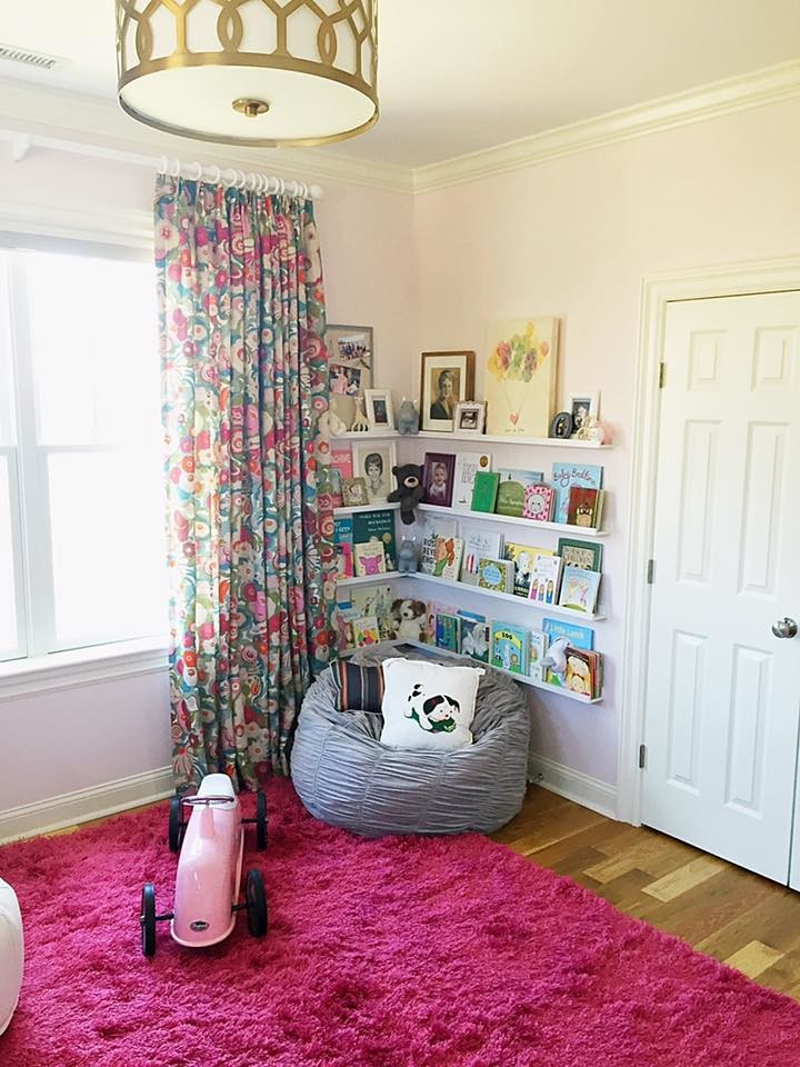 Photo of a mid-sized transitional nursery for girls in New York with pink walls and medium hardwood floors.