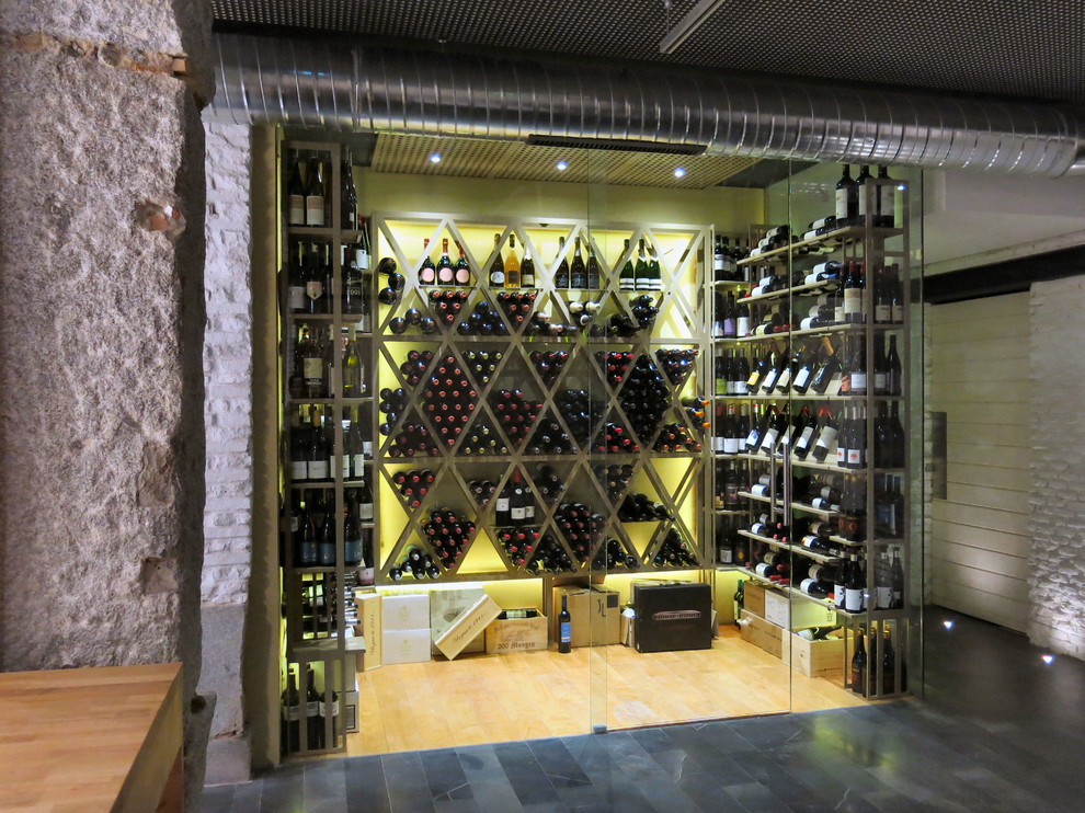 Design ideas for a mid-sized industrial wine cellar in Madrid with diamond bins.