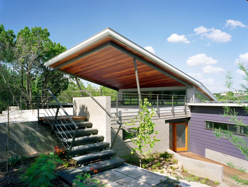 Design ideas for a large contemporary two-storey purple exterior in Austin with a flat roof and mixed siding.
