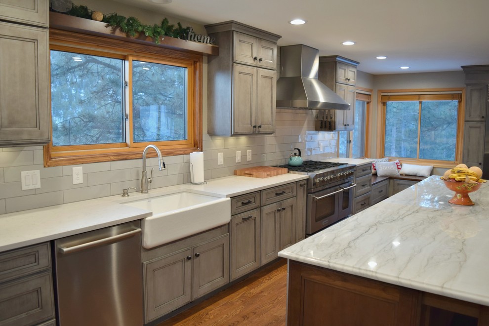 Inspiration for a huge transitional l-shaped medium tone wood floor open concept kitchen remodel in Denver with a farmhouse sink, flat-panel cabinets, gray cabinets, stainless steel appliances and an island