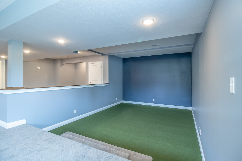 Cette photo montre un très grand sous-sol chic semi-enterré avec salle de jeu, un mur gris, moquette et un sol gris.