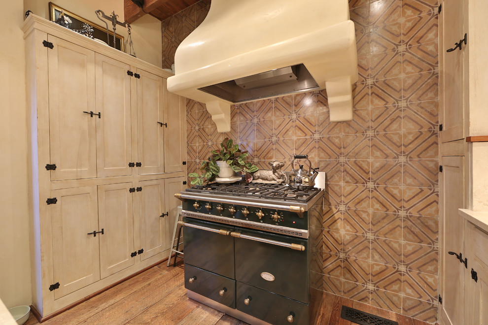 Open concept kitchen - mid-sized rustic single-wall medium tone wood floor and brown floor open concept kitchen idea in Austin with a farmhouse sink, shaker cabinets, white cabinets, an island, limestone countertops, multicolored backsplash and ceramic backsplash