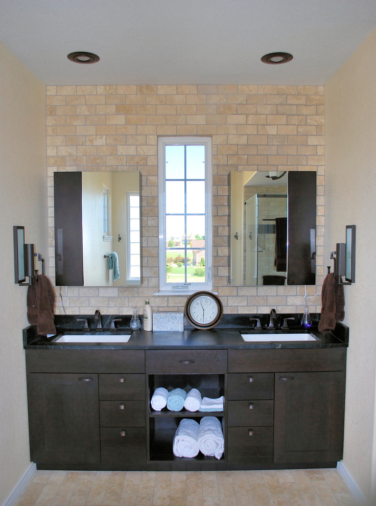 Inspiration for a large rustic master beige tile and subway tile beige floor and travertine floor freestanding bathtub remodel in Denver with shaker cabinets, dark wood cabinets, beige walls, an undermount sink, marble countertops and a hinged shower door