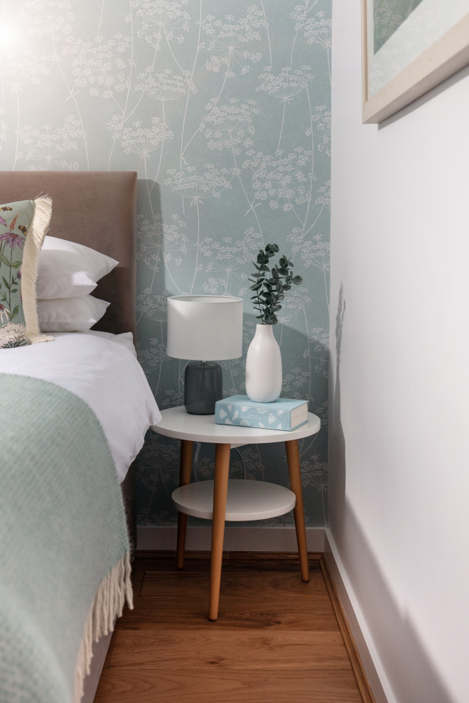 Inspiration for a small eclectic guest bedroom in Cornwall with blue walls, medium hardwood floors and wallpaper.