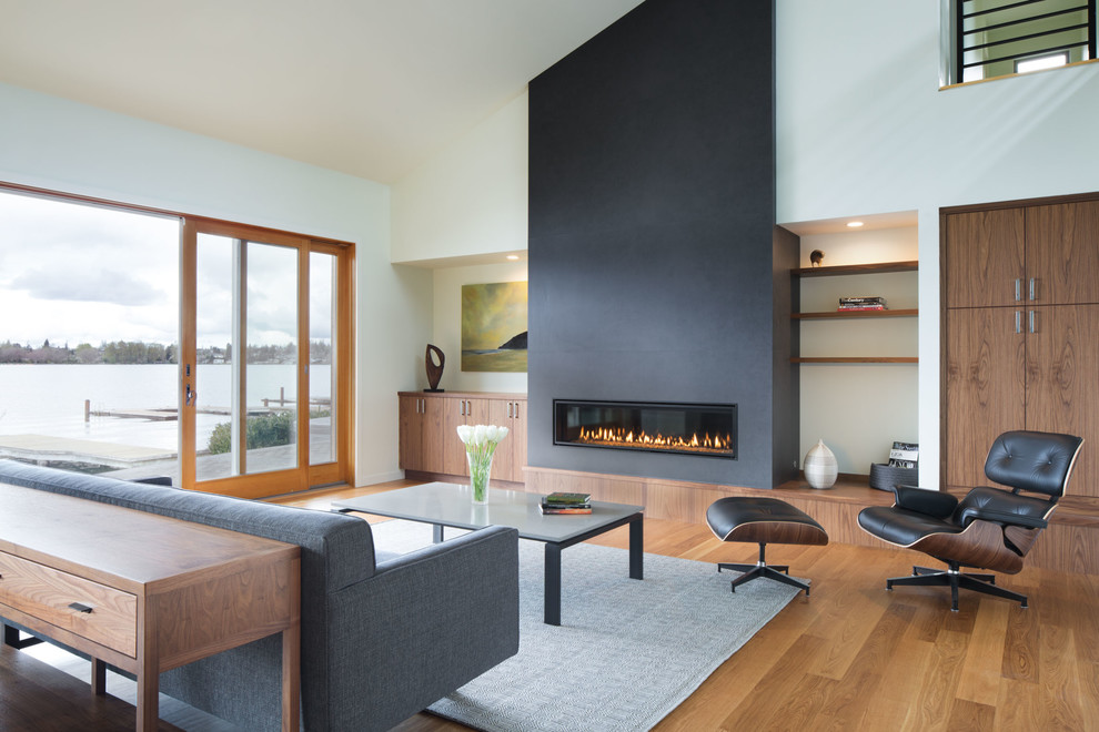 Design ideas for a contemporary open concept living room in Seattle with white walls, light hardwood floors, a ribbon fireplace and beige floor.
