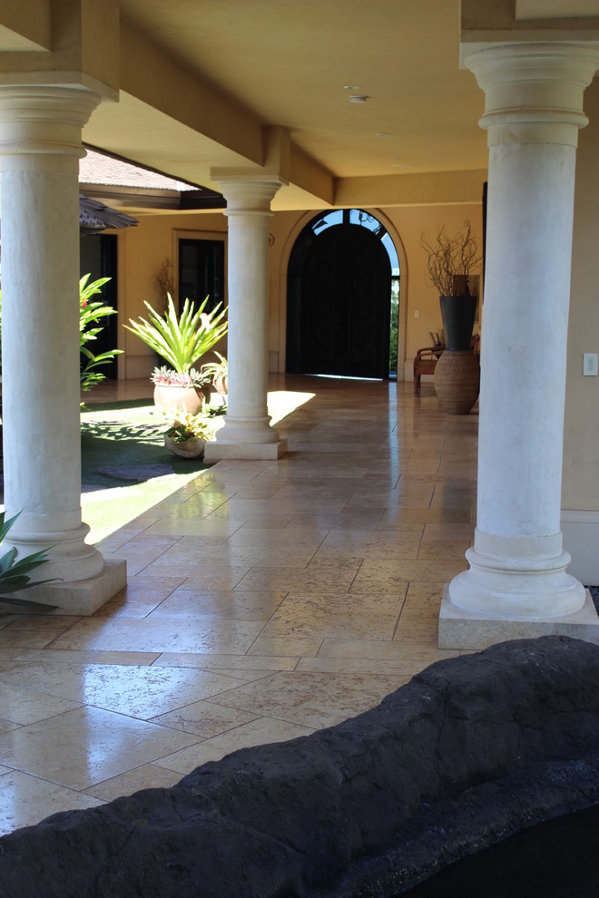 Photo of a large beach style courtyard patio in Hawaii with tile and a roof extension.