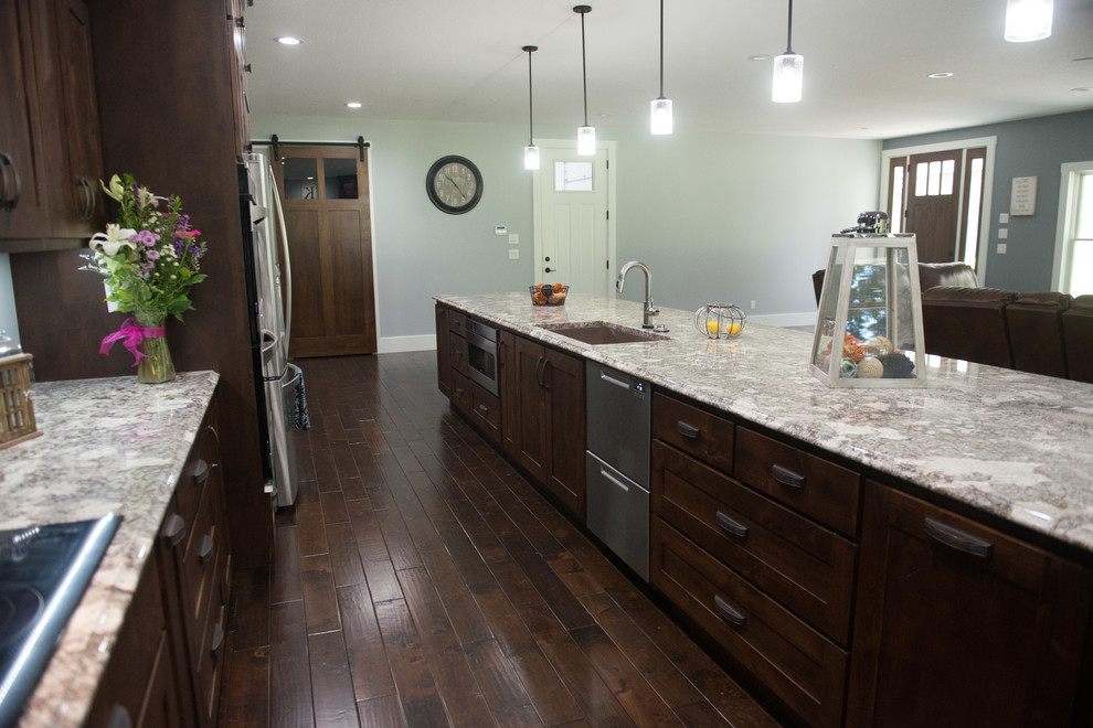 Example of a transitional l-shaped open concept kitchen design with an undermount sink, shaker cabinets, dark wood cabinets, granite countertops, stainless steel appliances, an island and multicolored countertops