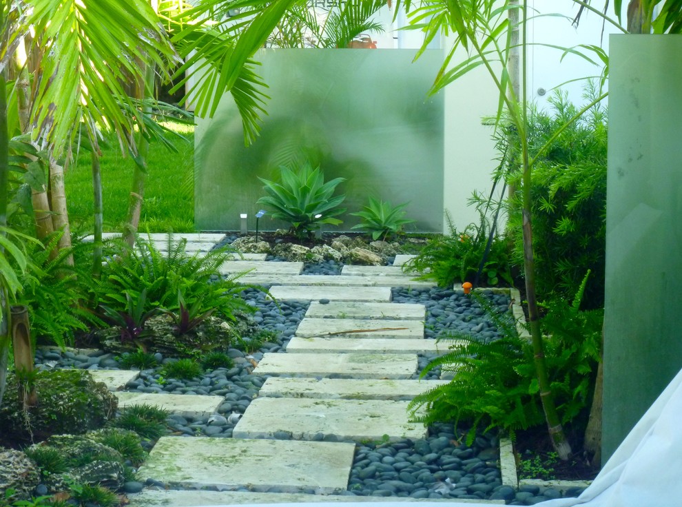 Bild på en tropisk trädgård i skuggan längs med huset