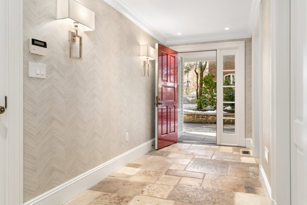 Photo of a large mudroom in Boston with beige walls, limestone floors, a single front door, a red front door and brown floor.