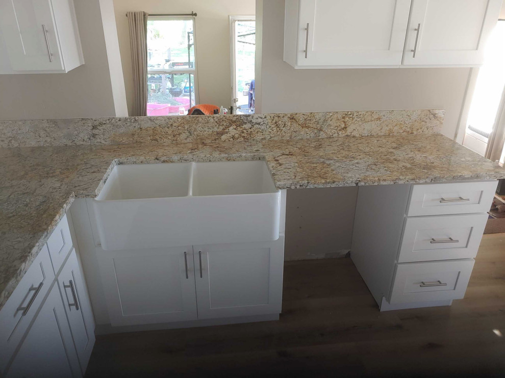 Design ideas for a small traditional u-shaped separate kitchen in Salt Lake City with a farmhouse sink, shaker cabinets, white cabinets, granite benchtops, vinyl floors, yellow floor and yellow benchtop.