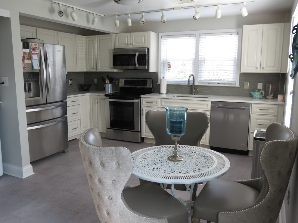 Example of a mid-sized transitional l-shaped purple floor eat-in kitchen design with an undermount sink, raised-panel cabinets, white cabinets, quartz countertops, gray backsplash, glass tile backsplash, stainless steel appliances, no island and white countertops