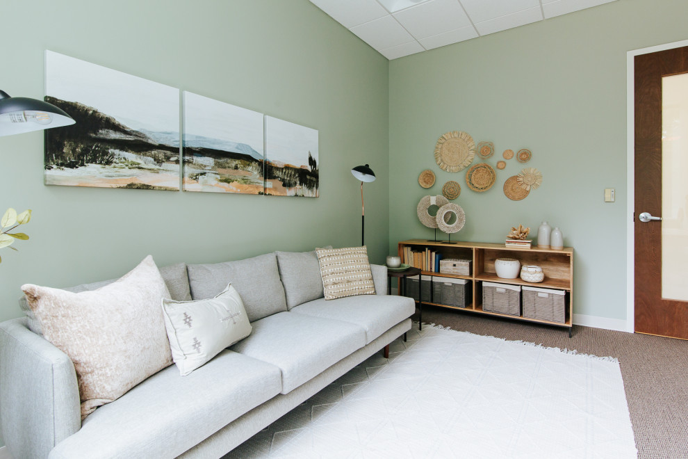 Cette image montre un très grand bureau minimaliste avec un mur vert et un sol marron.