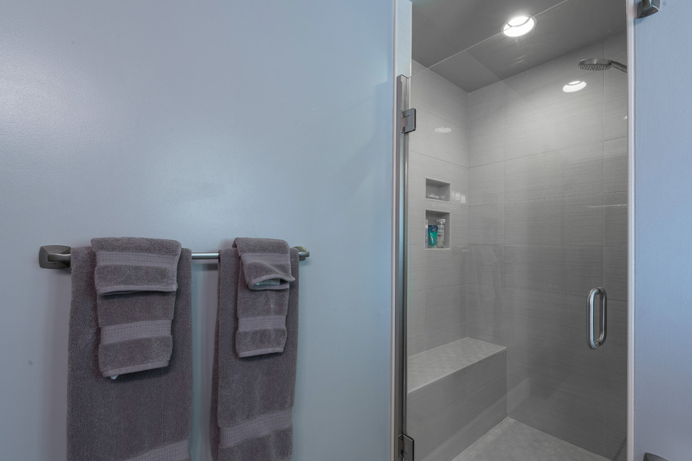 Example of a large transitional master gray tile and subway tile alcove shower design with shaker cabinets, dark wood cabinets, a two-piece toilet, blue walls, an undermount sink and granite countertops