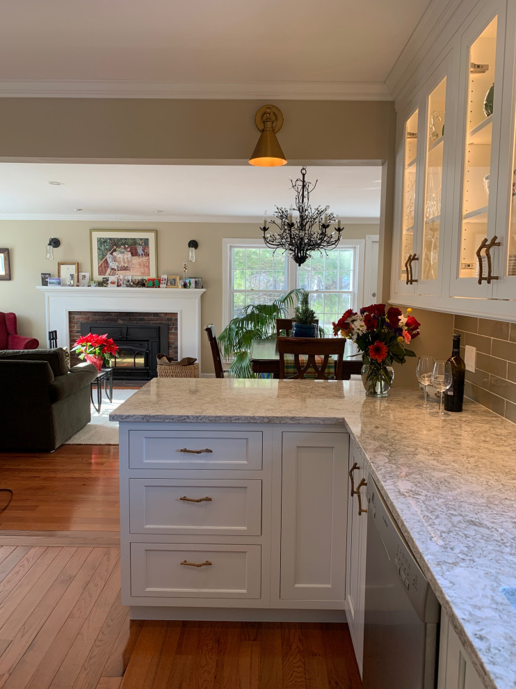Inspiration for a mid-sized transitional u-shaped kitchen remodel in Burlington with an undermount sink, flat-panel cabinets, white cabinets, quartz countertops, green backsplash, subway tile backsplash, stainless steel appliances, a peninsula and beige countertops