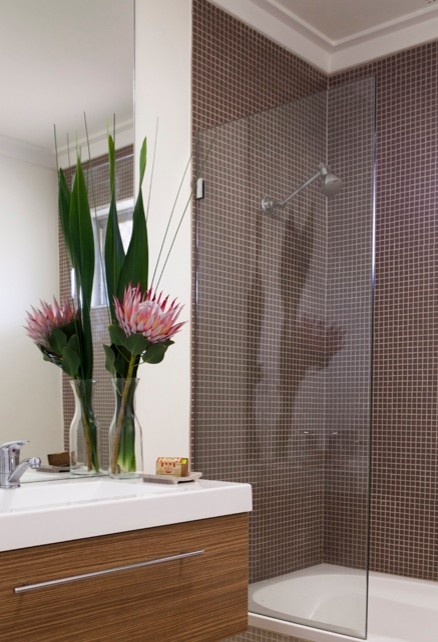 Inspiration for a small contemporary bathroom in Perth with flat-panel cabinets, medium wood cabinets, a shower/bathtub combo, brown tile, ceramic tile, white walls and ceramic floors.