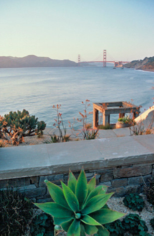 Photo of a mid-sized beach style sloped full sun xeriscape for winter in San Francisco with gravel and a retaining wall.