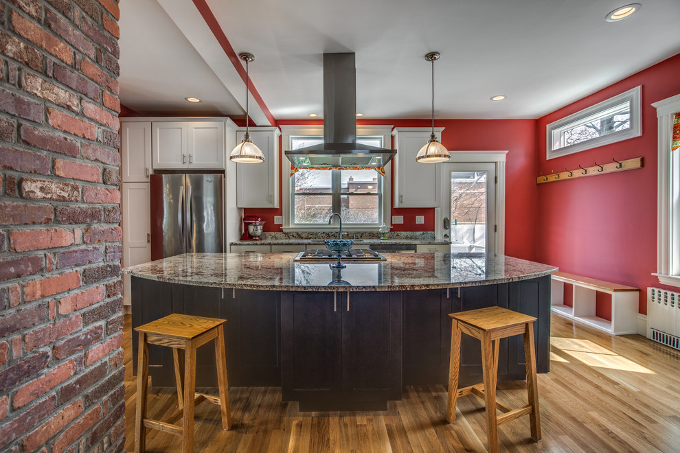 Mid-sized transitional galley light wood floor and beige floor eat-in kitchen photo in Boston with an undermount sink, shaker cabinets, white cabinets, granite countertops, red backsplash, stainless steel appliances and an island