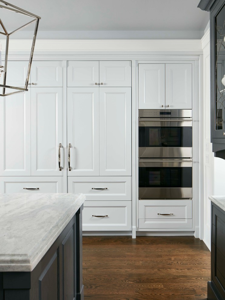 Inspiration for a traditional kitchen in Chicago with a double-bowl sink, recessed-panel cabinets, white cabinets, multi-coloured splashback, stainless steel appliances, dark hardwood floors and with island.