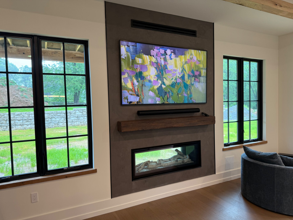 Example of a large country light wood floor, brown floor and exposed beam family room design in Philadelphia with a bar, a two-sided fireplace and a plaster fireplace