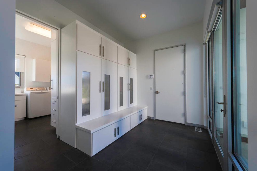 This is an example of a mid-sized contemporary mudroom in Other with white walls, porcelain floors, a single front door and a white front door.