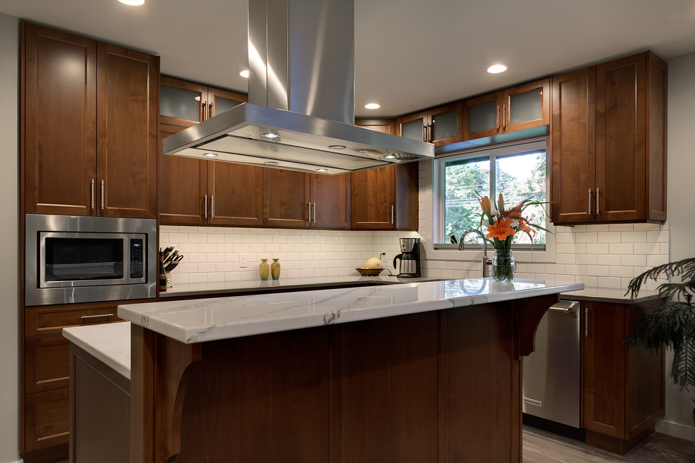 Inspiration for a mid-sized transitional u-shaped vinyl floor and multicolored floor kitchen pantry remodel with an undermount sink, shaker cabinets, medium tone wood cabinets, solid surface countertops, white backsplash, subway tile backsplash, stainless steel appliances and an island