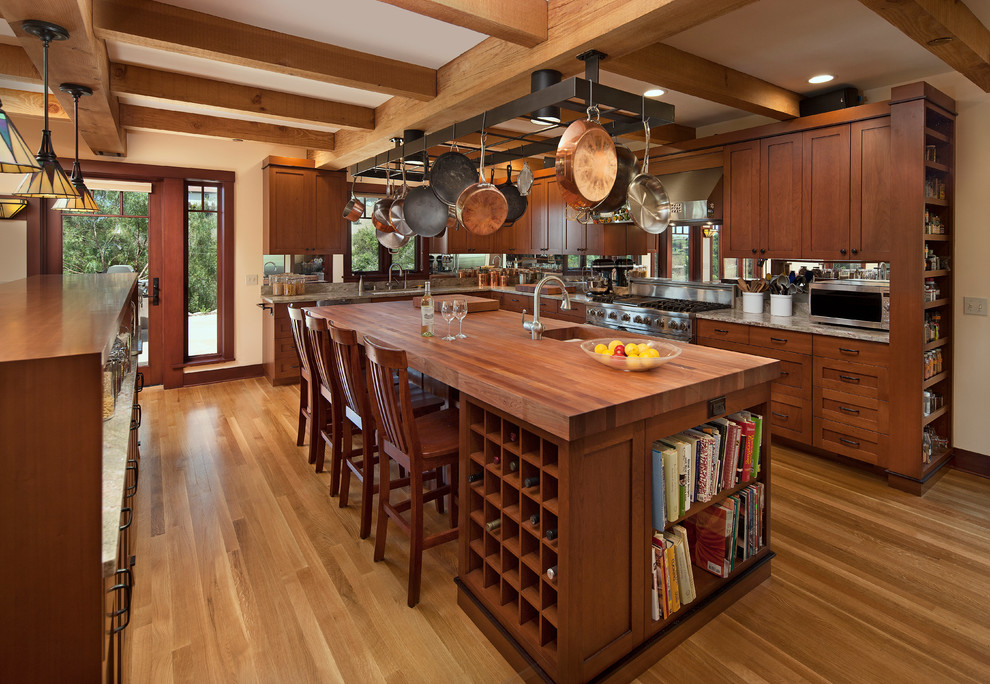 Inspiration for a mid-sized arts and crafts l-shaped separate kitchen in Santa Barbara with stainless steel appliances, recessed-panel cabinets, medium wood cabinets, mirror splashback, medium hardwood floors and with island.