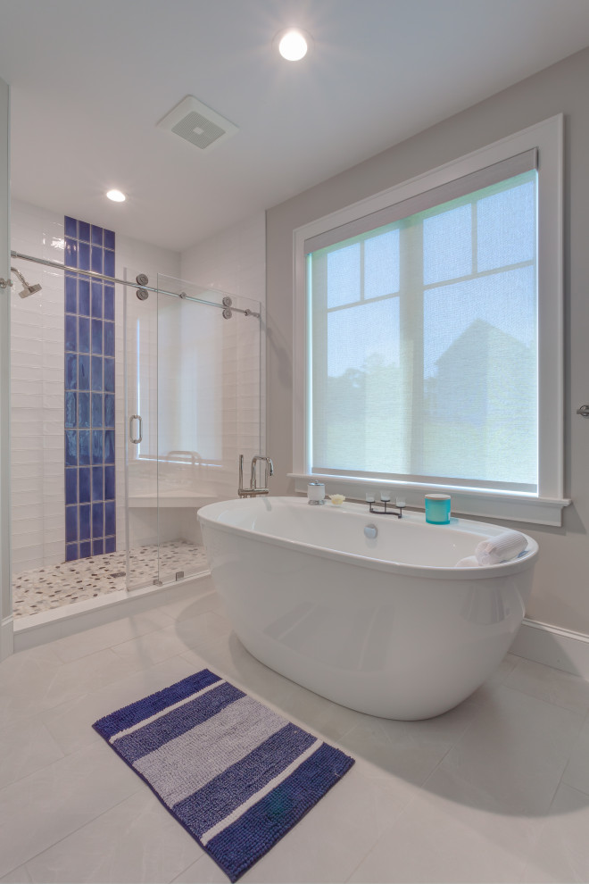 Photo of a contemporary ensuite wet room bathroom in Boston with a freestanding bath, blue tiles, grey walls, porcelain flooring, grey floors, a sliding door, a shower bench and metro tiles.