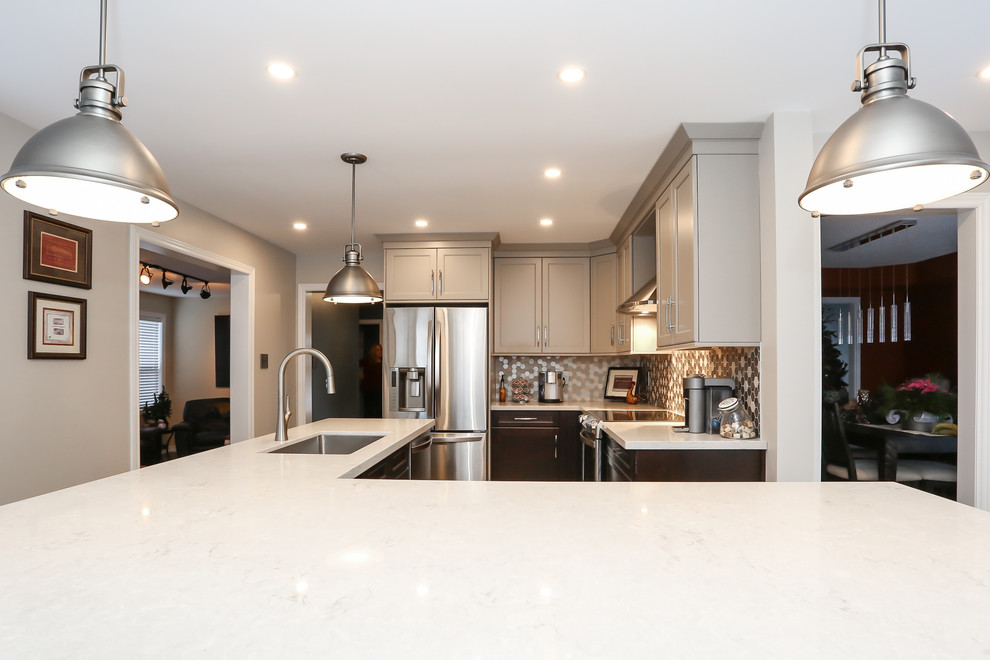 Enclosed kitchen - mid-sized transitional l-shaped porcelain tile enclosed kitchen idea in Toronto with an undermount sink, recessed-panel cabinets, gray cabinets, quartz countertops, gray backsplash, mosaic tile backsplash, stainless steel appliances and an island
