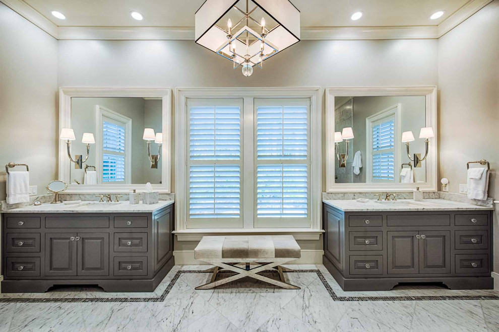 Freestanding bathtub - master marble floor, multicolored floor and double-sink freestanding bathtub idea with raised-panel cabinets, gray cabinets, a one-piece toilet, gray walls, an undermount sink, marble countertops, multicolored countertops and a freestanding vanity
