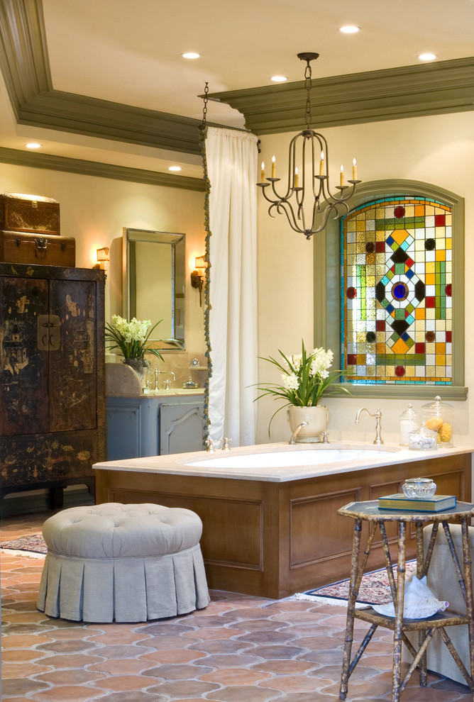 Inspiration for a mediterranean bathroom in Other with an undermount tub, multi-coloured tile, beige walls, terra-cotta floors and recessed-panel cabinets.