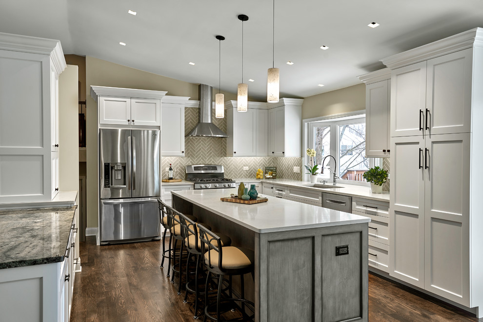 Photo of a transitional u-shaped kitchen in Chicago with an undermount sink, shaker cabinets, white cabinets, grey splashback, stainless steel appliances, dark hardwood floors, with island, brown floor and white benchtop.