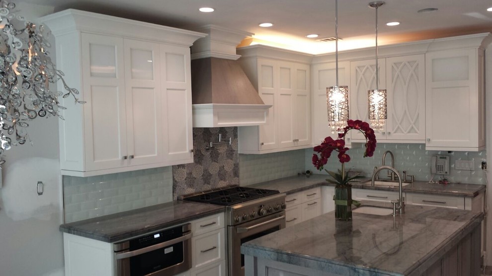 Mid-sized transitional l-shaped kitchen photo in New York with shaker cabinets, white cabinets, an undermount sink, marble countertops, glass tile backsplash, stainless steel appliances and an island
